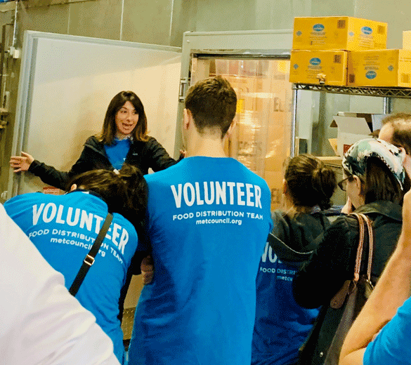 UJA Federation of New York >> Jessica Chait, managing director of food programs at Met Council, with volunteers at the warehouse.