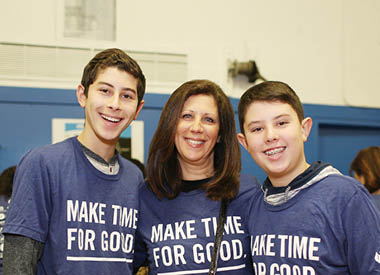 Three volunteers standing together in a community setting